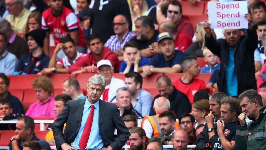 Arsene Wenger of Arsenal looks on as a fan behind makes his feelings known during the Barclays Premier League defeat to Aston Villa at Emirates Stadium. Photograph: Clive Mason/Getty Images