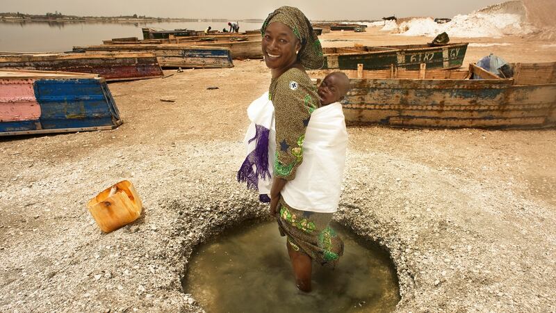 A mother with child washes her feet in a fresh water hole on the shore of Lac Rose, Senegal. Photograph: Lar Boland