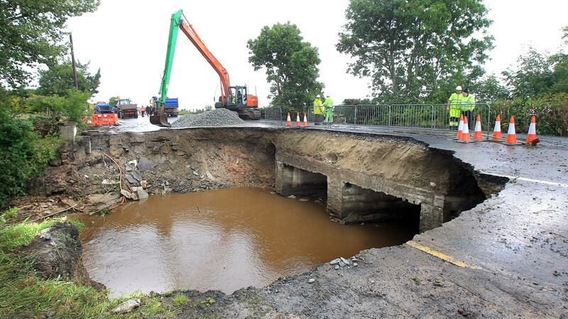 The scene on the main Derry to Moville Road close to Quigley’s Point in Donegal as men attempt to repair flood damage. Photograph: Margaret McLaughlin