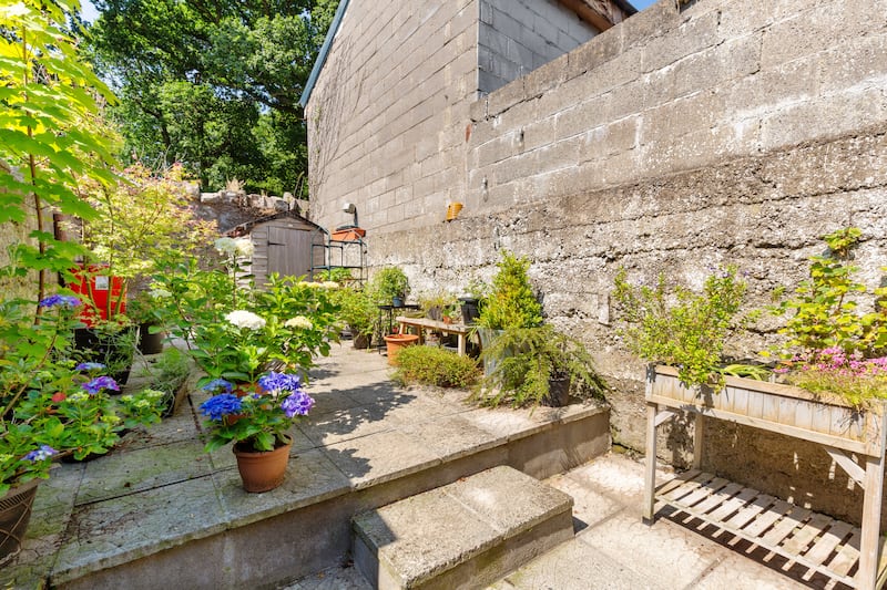 The south-facing back garden is low-maintenance, with paving and a lovely stone wall to the rear. Photograph: Keith Owens