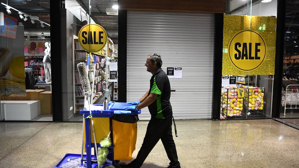 A cleaner walks through a deserted outlet centre in Brisbane, Australia. Photograph: Dan Peled/EPA