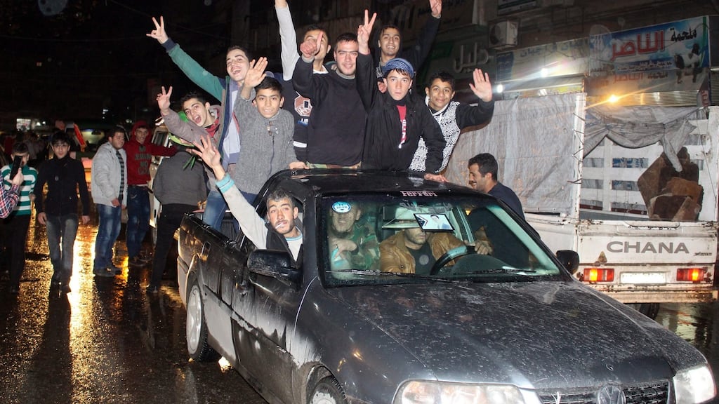 Residents of a government-controlled district of Aleppo celebrate on Monday after regime fighters made major gains in their assault on rebel-held areas of the city. Photograph: EPA