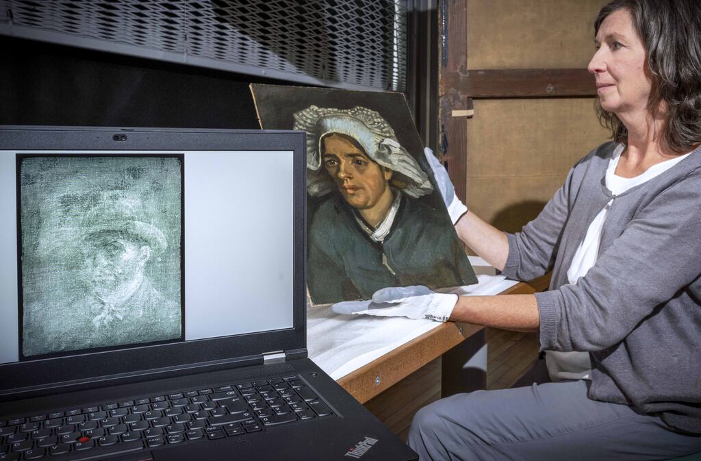 Senior conservator Lesley Stevenson views Head of a Peasant Woman alongside an X-ray image of the hidden Van Gogh self-portrait. The X-ray self portrait of Van Gogh was found on the back of the painting. Photograph: PA Media
