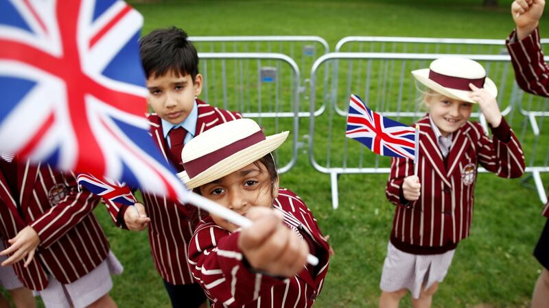 School children in uniform wave Union Flags outside Windsor Castle ahead of Prince Harry and Meghan Markle’s wedding, in Windsor. Photograph: Damir Sagolj/Reuters