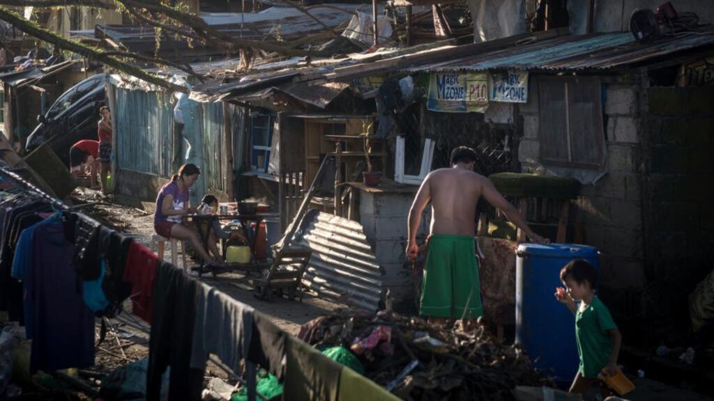 Survivors of the typhoon in Tacloban go about their daily lives amid the wreckage. The official death toll for for the city rose to 2,000 yesterday. Photograph: Sergey Ponomarev/New York Times