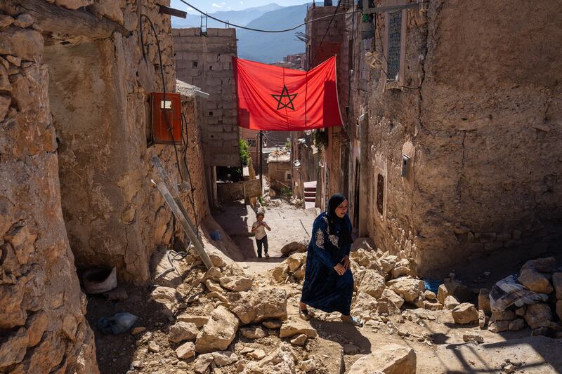 A woman walks past the rubble of damaged buildings following the powerful earthquake, in Moulay Brahim, Morocco. Photograph: Carl Court/Getty