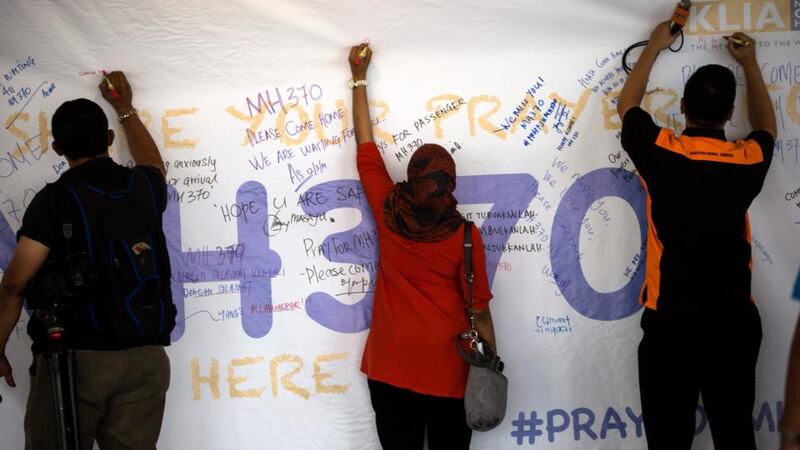 Journalists write notes about the missing Malaysian Airlines flight on a board at Kuala Lumpur International Airport in Malaysia today. Photograph: Ahmad Yusni/EPA