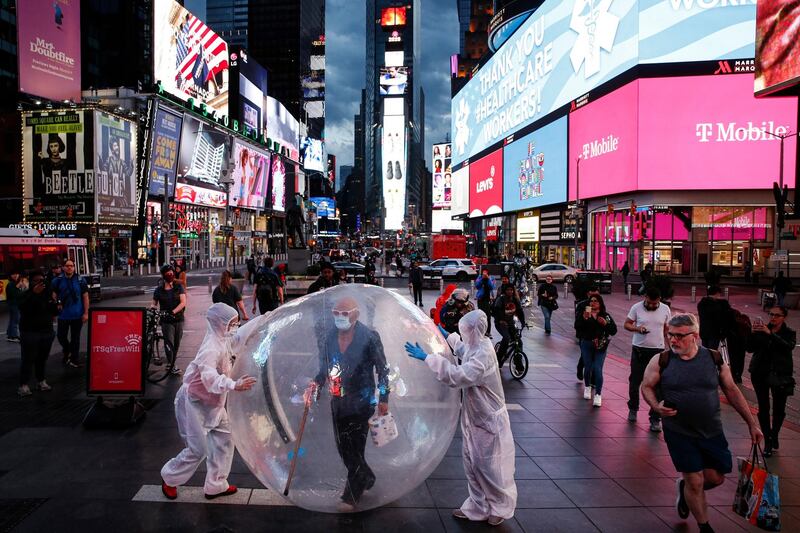 Artists perform under a billboard displaying thanks to healthcare workers due to Covid-19 concerns in a sparsely populated Times Square, in New York. Photograph: John Minchillo/AP Photo