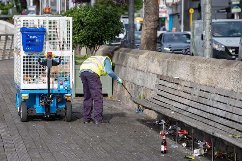 A Dublin City Council staff cleans litter on the Liffey Boardwalk, in Dublin. Photograph: Tom Honan