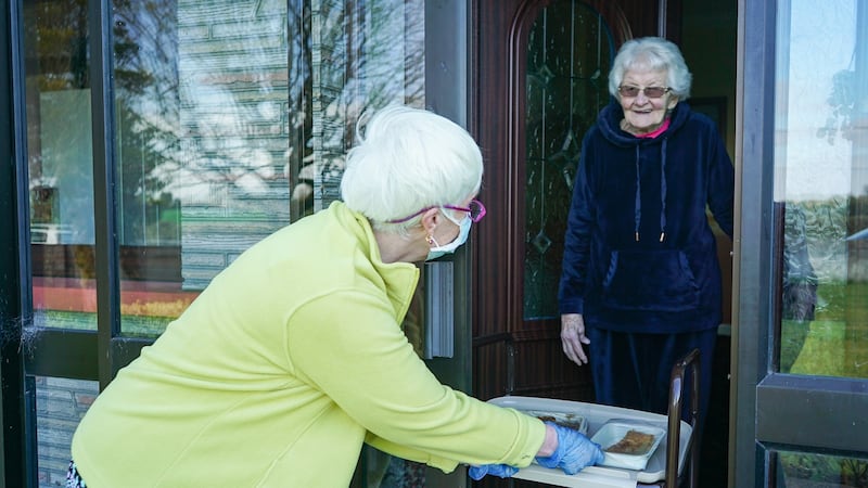Mary Brady receives a hot meal from Imelda Ward. Brady has been living alone since her husband moved into a nearby nursing home. Photograph: Enda O’Dowd