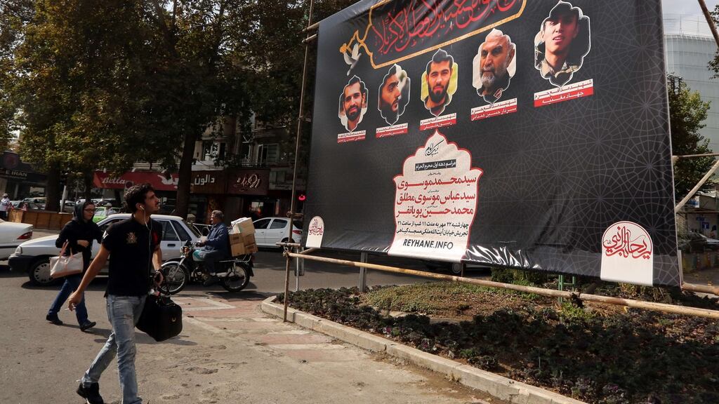 Iranians walk past a banner showing a portrait of soldiers killed by Islamic State militants during a mission in Aleppo in Syria. Photograph: Atta Kenare/AFP/Getty Images