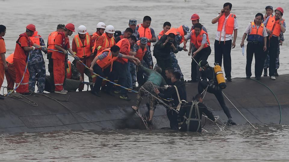 Rescuers take a survivorfrom the overturned passenger ship in the Jianli section of the Yangtze River. Photograph: Xinhua News Agency