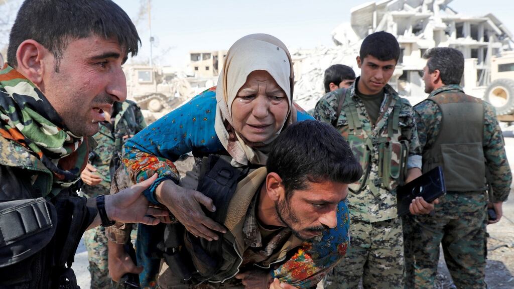 Fighters of the Syrian Democratic Forces evacuate a civilian from a stadium after Raqqa was liberated from Islamic State militants in Syria on Tuesday. Photograph: Erik De Castro/Reuters