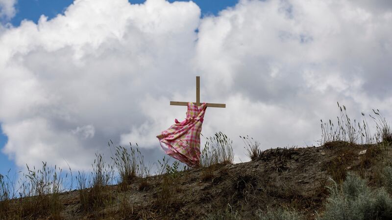 A staked child’s dress blows in the wind on Highway 5, representing an ongoing genocide against First Nations people in Canada, near the former Kamloops Indian Residential School, where the remains of 215 children were discovered buried near the facility, in June , 2021. Photograph: Cole Burston/AFP via Getty Images