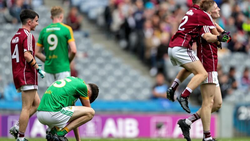 Meath’s Luke Mitchell is dejected at the final whistle as Galway players celebrate  in the the All-Ireland MFC semi-final against Meath at Croke Park. Photograph: Laszlo Geczo/Inpho