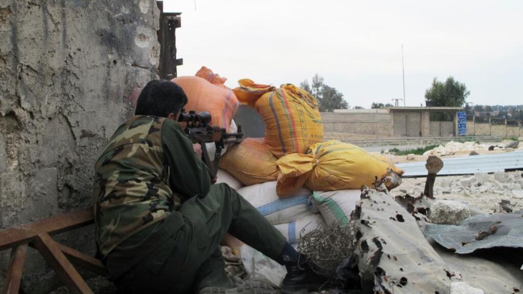 A Free Syrian Army fighter takes position behind sandbags in Aleppo earlier this week. Photograph: Abdalghne Karoof/Reuters