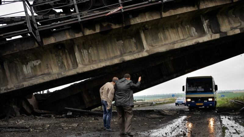 A bus drives under a rail bridge which was blown up near Donetsk recently. Photograph: EPA/STR.
