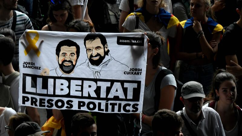 Protesters against the sentences handed down to Catalan independence leaders hold a banner reading ‘Free political prisoners’ at El Prat airport in Barcelona on Monday. Photograph: Lluis Gene/AFP via Getty Images