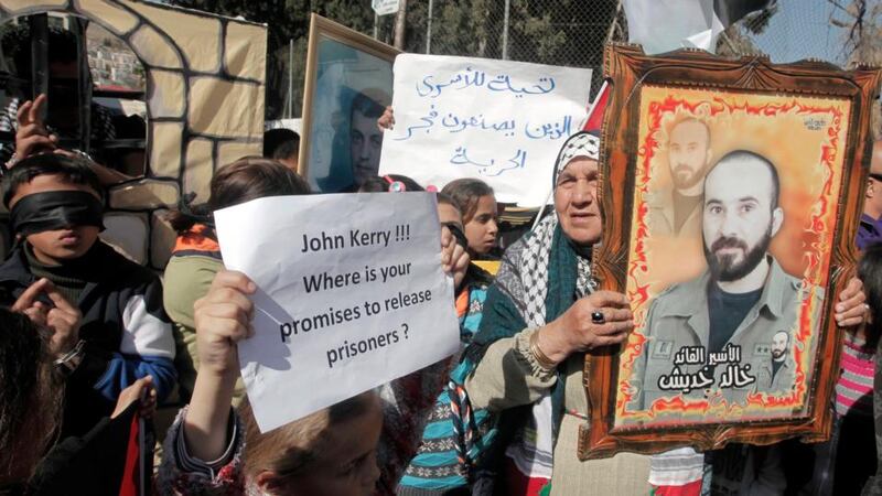 Palestinians hold placards during a protest demanding US secretary of state John Kerry work for the release of Palestinian prisoners in Israeli jails at Balata refugee camp near the West Bank city of Nablus yesterday. Photograph: Alaa Badarneh/EPA