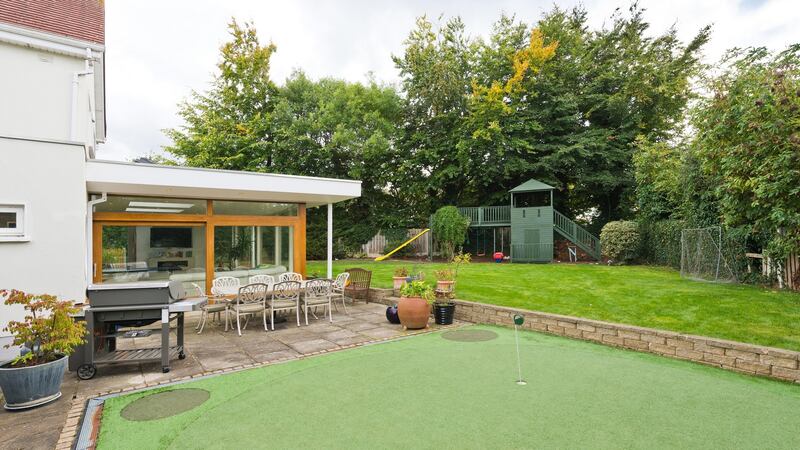 The large garden with putting green and playhouse.