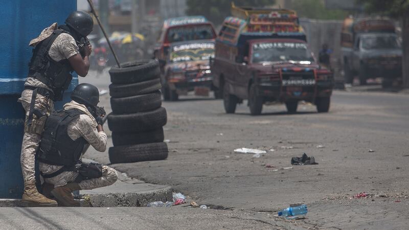 Police take shelter during a demonstration by the G9 gang. Photograph: Victor Moriyama/The New York Times