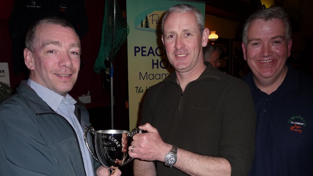 Alan Hough, centre, accepting the Ignatius Cup from John Burke, left, and Tómas Burke