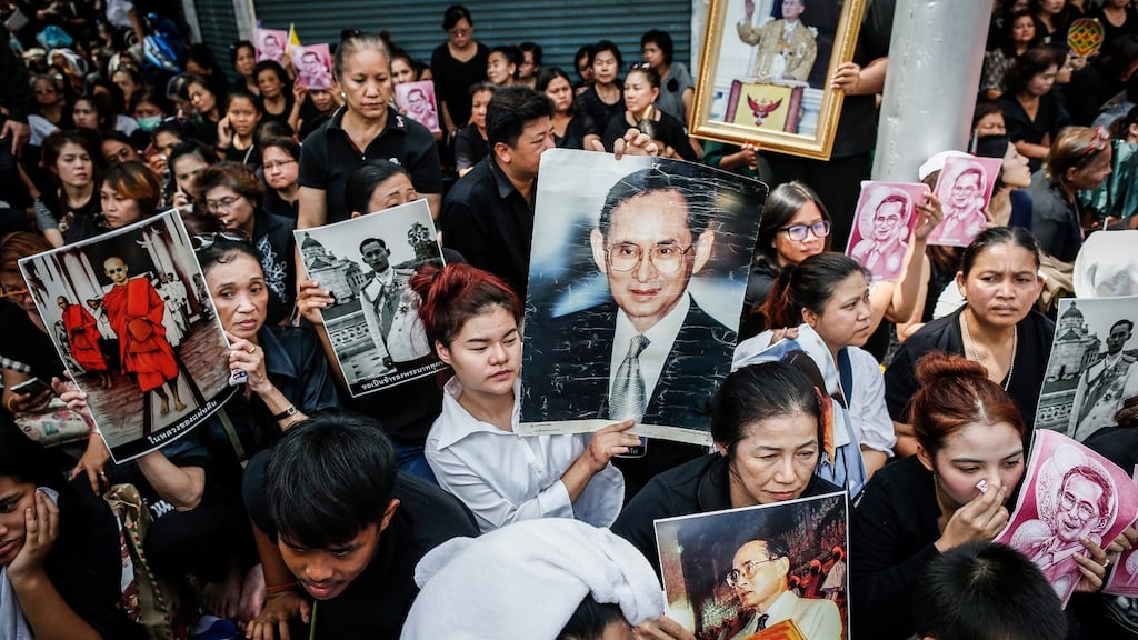 Thais hold pictures of the late King Bhumibol Adulyadej as they wait for the procession to move the body outside Siriraj Hospital in Bangkok. Photograph: EPA/RUNGROJ YONGRIT
