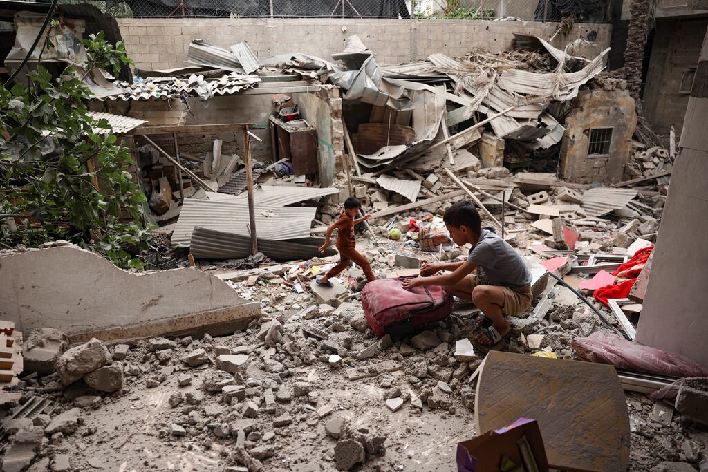 A Palestinian child salvages objects amid the debris of a house destroyed by overnight Israeli bombardment in Rafah in the southern Gaza Strip. Photograph: AFP/Getty