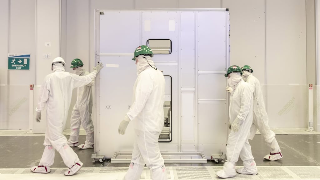 Workers at Intel Ireland moving the new chipmaking tool into place.