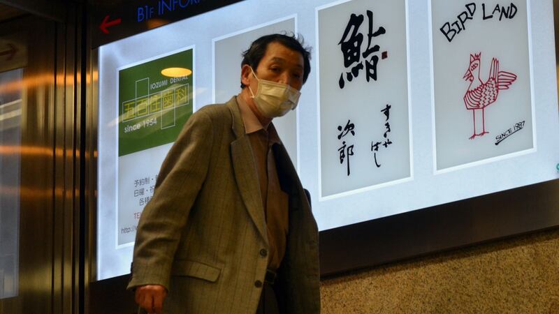 A man passes an advertisement board of Sukiyabashi Jiro in Tokyo. The restaurant was stripped of its Michelin because it no longer opens to the general public. Photograph: Yoshikazu Tsuno/AFP via Getty Images