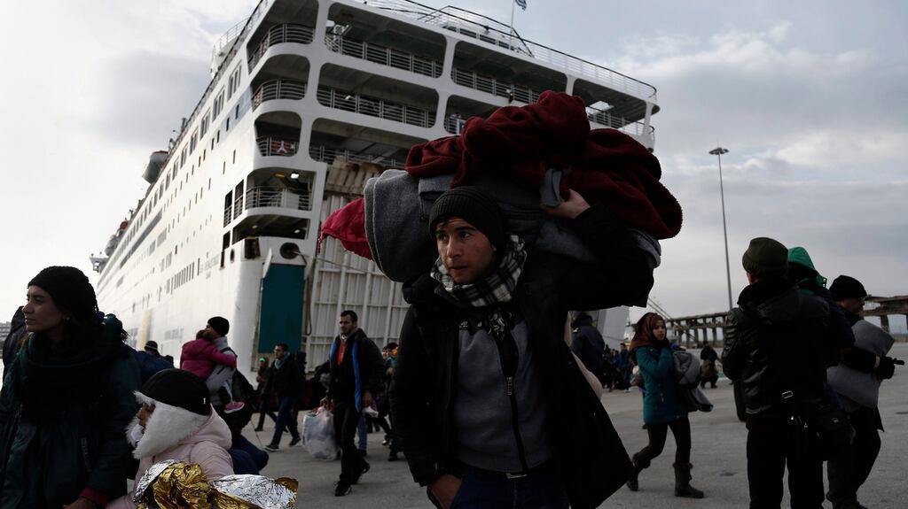 Refugees and migrants walk after disembarking from the ferry ‘Eletherios Venizelos’ at the port of Piraeus, near Athens, Greece. The ship was carrying about 2,500 refugees and migrants that had landed on the Greek island of Myilene, coming from Turkey. Greece is under pressure from EU colleagues to control the flow of migrants into the union. Photograph: Yannis Kolesidis/EPA.