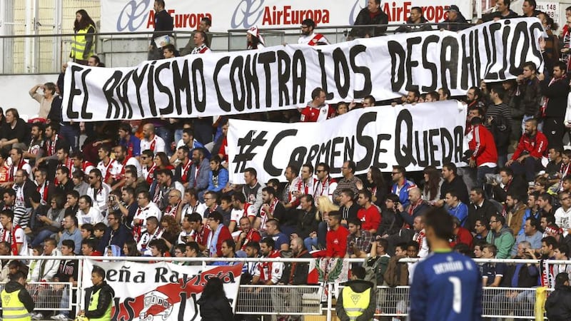 Rayo Vallecano fans hold a banner reading ‘Rayo’s fans against evictions’ and ‘#Carmen is staying’ during the club’s match against Celta Vigo at Vallecas Stadium in Madrid on Sunday. The club is to help Vallecas resident Carmen Martínez, who was evicted from her house on November 21st. Photograph: Sergio Barrenechea/EPA