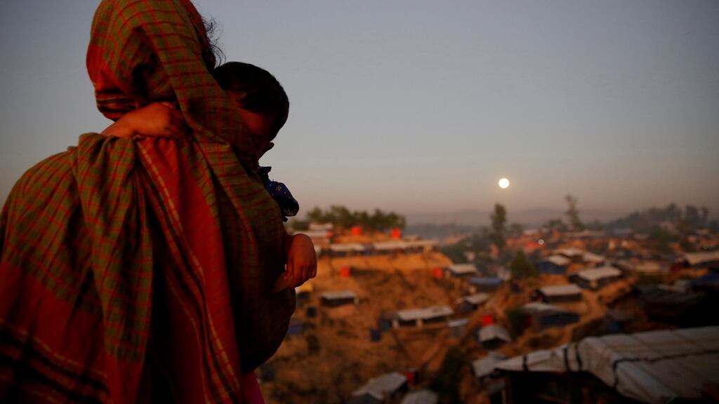 A Rohingya refugee carrying a child looks at the full moon at Balukhali refugee camp near Cox’s Bazar, Bangladesh, late last year. File photograph: Susana Vera/Reuters
