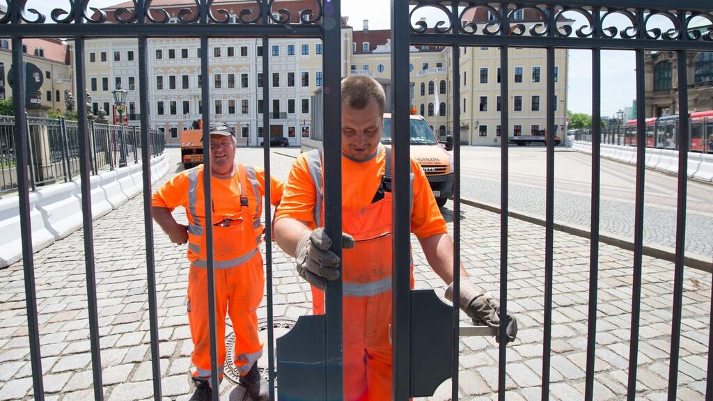 Workers install a fence in front of Hotel Taschenbergpalais in Dresden, which hosts the Bilderberg conference. Here politicians, business leaders, academics and media representatives will discuss world affairs behind closed doors. Photograph: Sebastian Kahnert/EPA