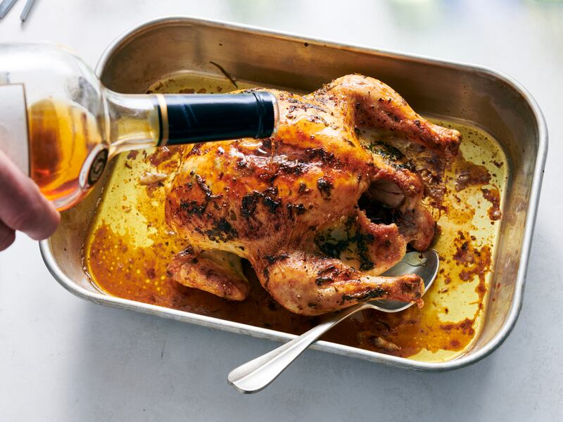 A bit more Cognac is added before the bird is returned to a turned-off oven. Photograph: David Malosh/The New York Times