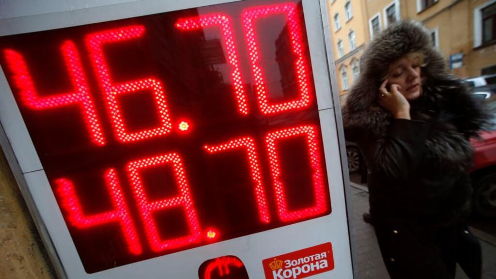 A woman walks past a board showing currency exchange rates in St Petersburg. The rouble has been laid low by plunging oil prices and western sanctions over Ukraine. Photograph: Reuters/Alexander Demianchuk