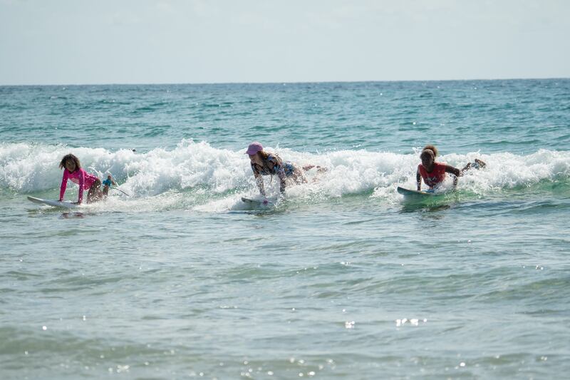 Tofo Beach: Nahla O'Connell, Grace Doyle and Aliya Seco ride the wave. Photograph: Ritchie Hunt