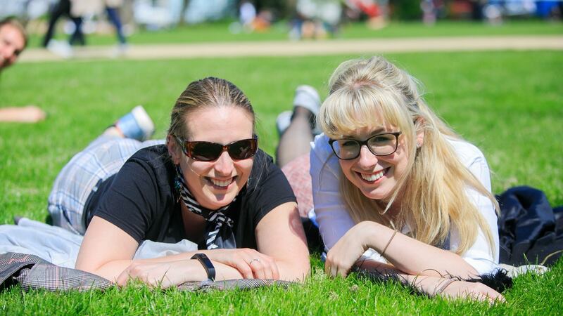 Jil Kellegher (left) from Portobello and Evan Farren from Stillorgan soak up the sun in Merrion Square, Dublin. Photograph: Collins