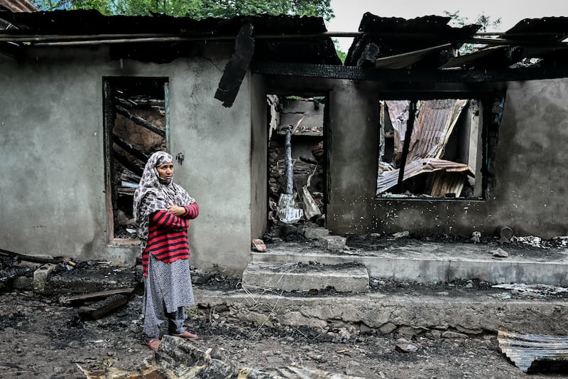 A woman stands outside a house destroyed by Pakistani artillery shelling about 100km from Srinagar. Photograph: Sajjad Hussain/AFP via Getty Images