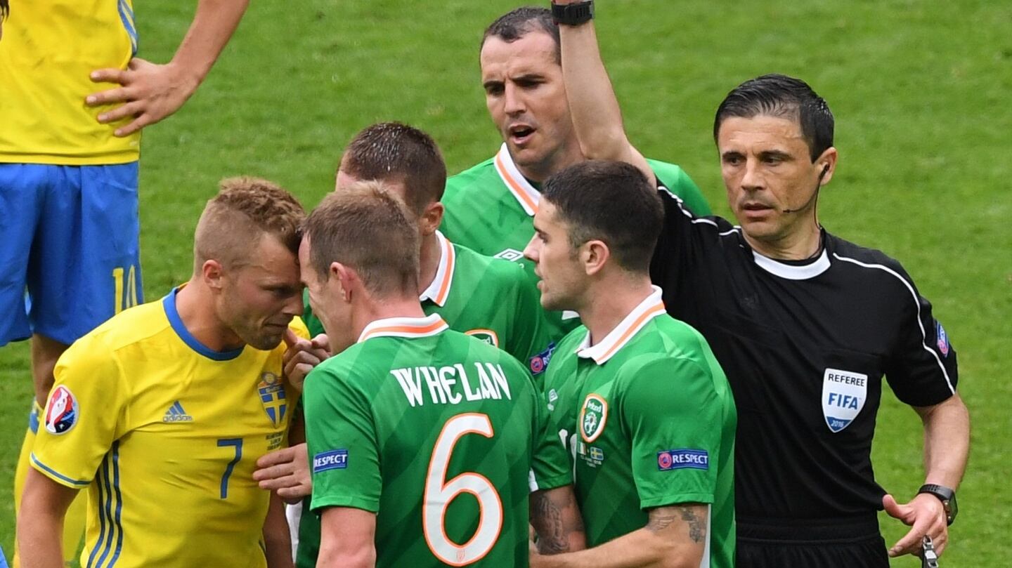 Glenn Whelan  is handed a yellow card by Serbian referee Milorad Mazic. Photo: Getty Images