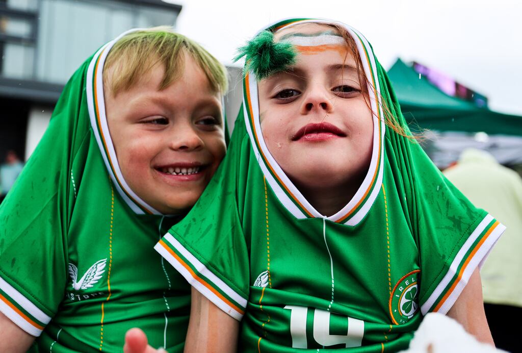 Ireland fan Jaxon Miles and cousin of Abbie Larkin Rheia Larkin protect themselves from the rain during the 2023 FIFA Women's World Cup Group B Australia vs Republic of Ireland at Ringsend, Dublin. Photograph: INPHO/Tom Maher