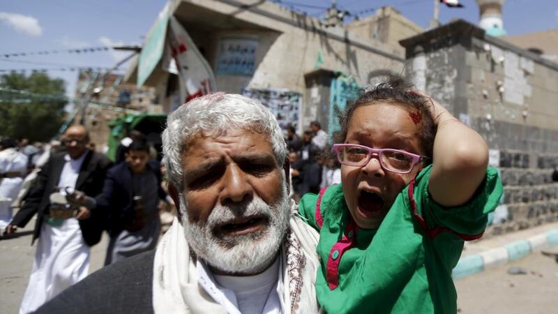 An injured child is carried from one of the mosques attacked by the extremists in Sanaa. Photograph: Khaled Abdullah/Reuters.
