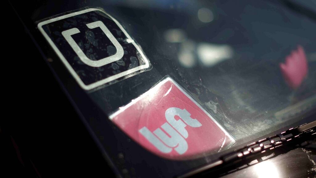 Signs for Uber and Lyft displayed in a car window. Photograph: Lucy Nicholson/Files/Reuters