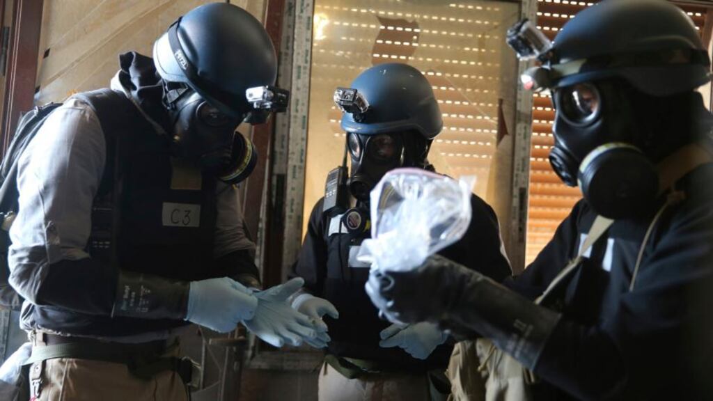A UN chemical weapons expert, wearing a gas mask, holds a plastic bag yesterday containing samples from one of the sites of an alleged chemical weapons attack in the Ain Tarma neighbourhood of Damascus. Photograph: Mohamed Abdullah/Reuters