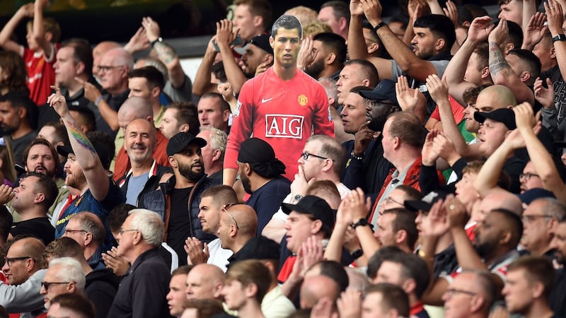 A cardboard cut-out of new signing Cristiano Ronaldo is held by Manchester United supporters during the  Premier League clash against Wolves at    Molineux.  Photograph: Oli Scarff/AFP/Getty