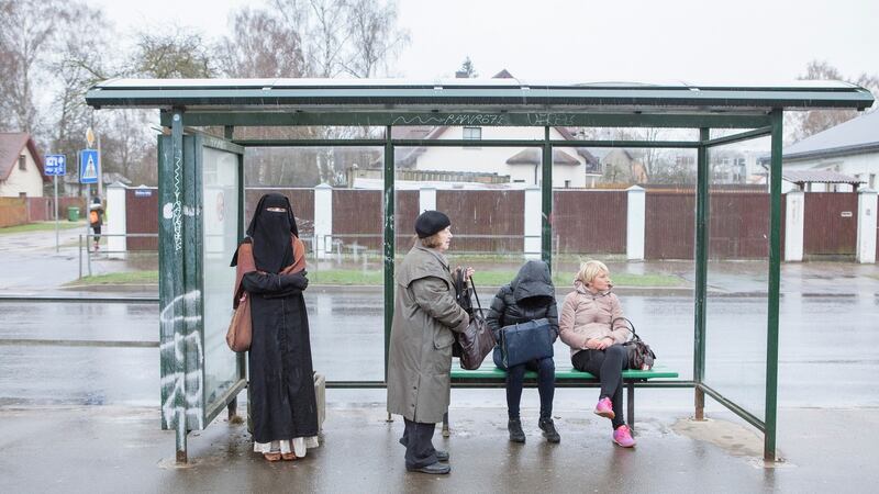 Liga Legzdina, a native Latvian who converted to Islam, waits for a bus in a suburb of Riga. With a tiny minority of Muslims to join the dialogue, the public debate in Latvia has splayed outward to the extremes. Photograph: Reinis Hofmanis/The New York Times