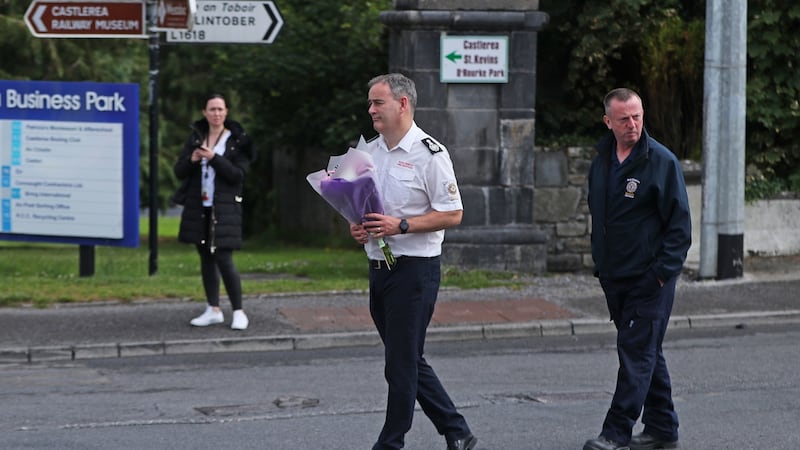 Members of the fire service carry flowers to the scene in Castlerea, Co Roscommon, where Det Gda Colm Horkan was shot dead on Wednesday night. Photograph: Niall Carson/PA Wire