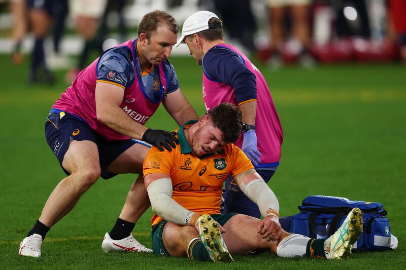 Australia backrow Carlo Tizzano receives treatment after the clearout by the Lions' Jac Morgan at a ruck in the lead-up to Hugo Keenan's late try at the MCG. Photograph: Morgan Hancock/Getty Images