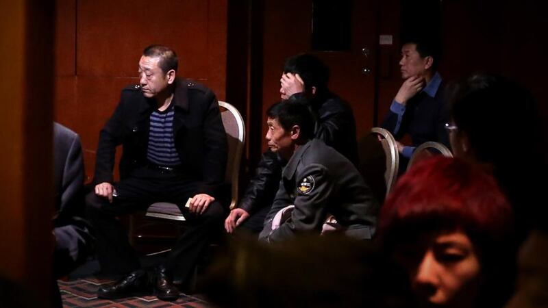 Relatives of missing passengers travelling onboard Malaysia Airlines flight MH370 watch a television displaying a press conference with Malaysian Prime Minister, in Beijing, China. Photograph: Getty Images