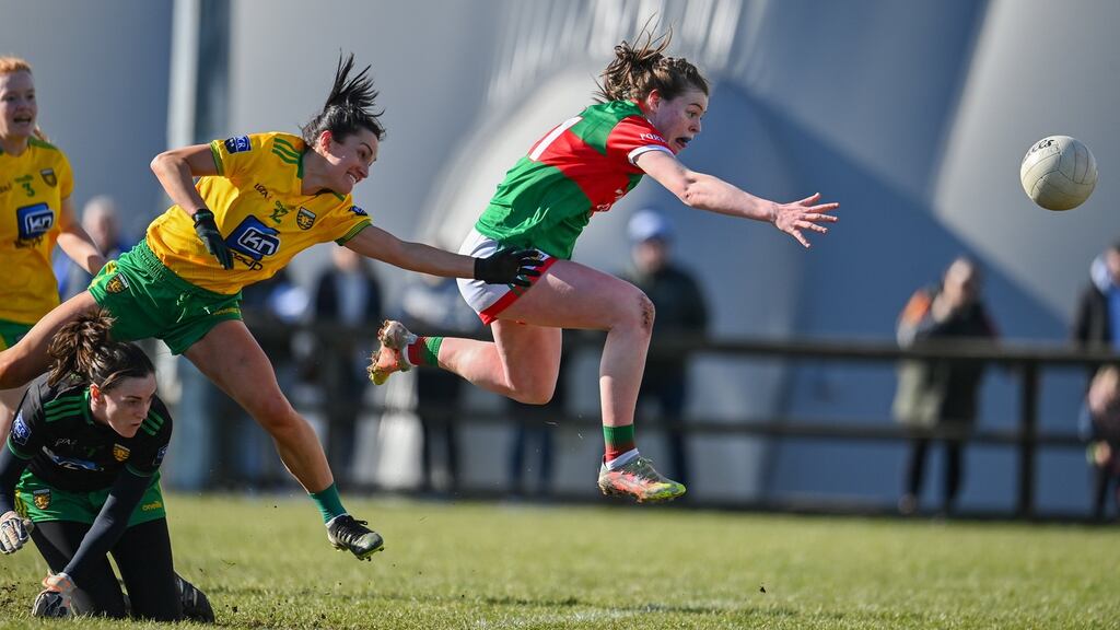 Sinead Walsh of Mayo scores her side's first goal despite the efforts of Shelly Twohig of Donegal. Photograph: Sam Barnes/Sportsfile